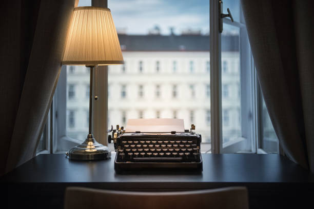 Workplace of a writer, journalist, creator. An old typewriter and a lamp on the table. Retro style. The concept on scientific, historical, literature, education and philosophical topics.